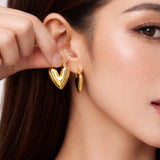 SALVE hinged hoop heart earrings, gold-tone earrings with heart-shaped design and hinged closure, shiny and stylish jewelry.