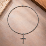 Silver-toned SALVE cross pendant necklace featuring a detailed cross design on a chain.