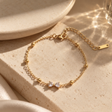 Gold-toned SALVE bow bracelet featuring a delicate bow design on a sleek bracelet for elegant style.