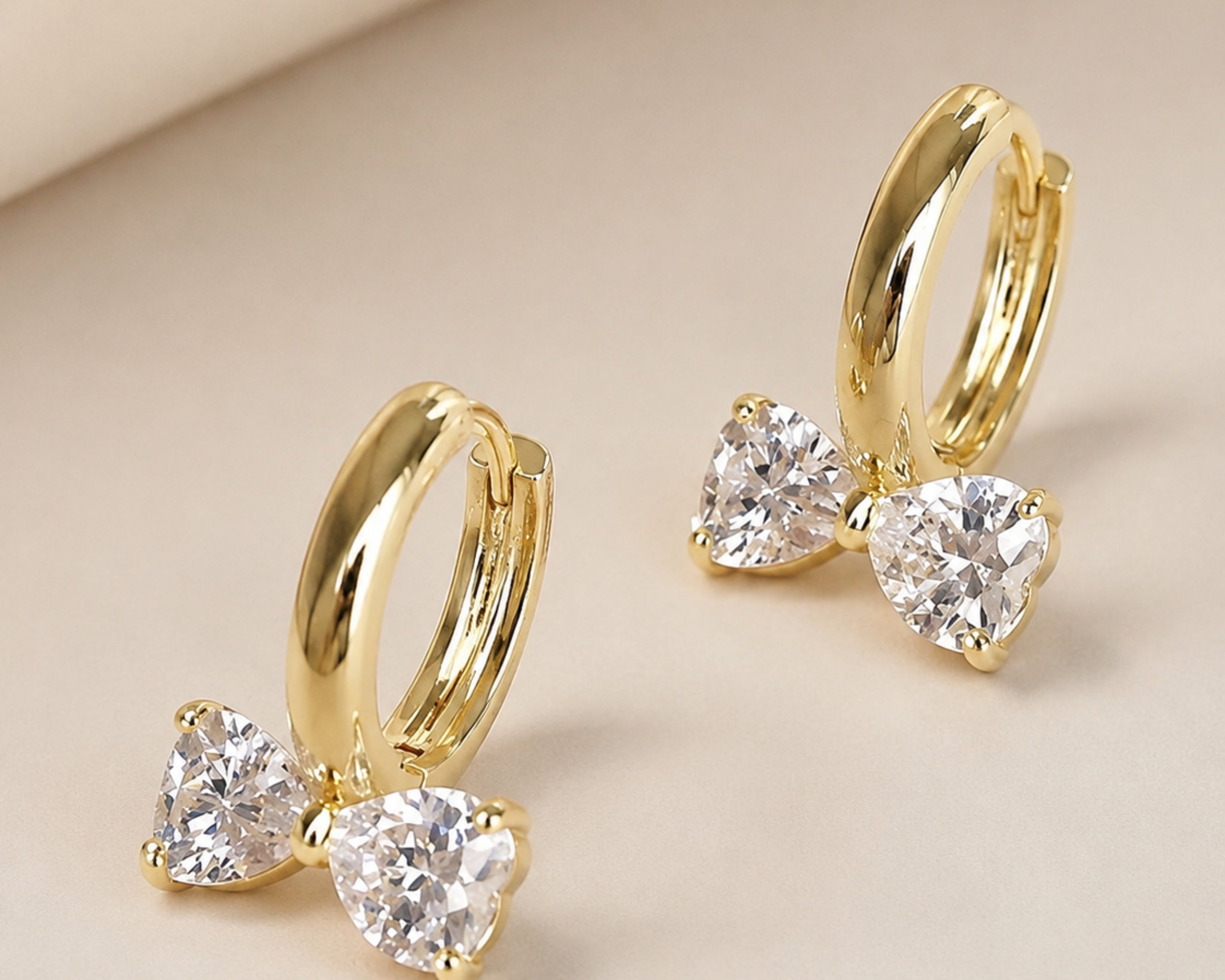 Gold tone SALVE bow heart hoop earrings featuring heart-shaped charms and hoop design, stylish jewelry for women