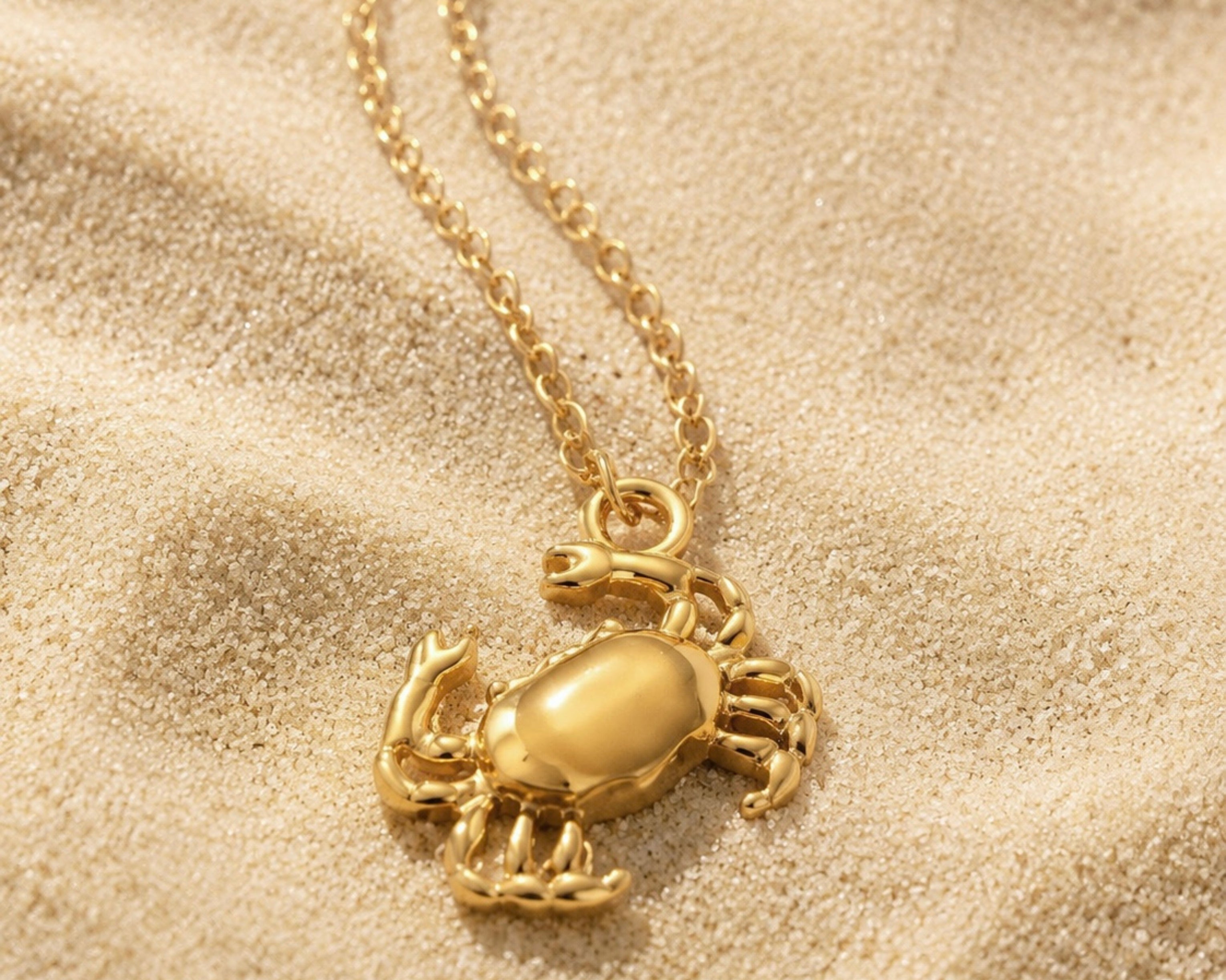 Gold-tone crab pendant necklace by SALVE featuring a detailed crab charm on a delicate chain.