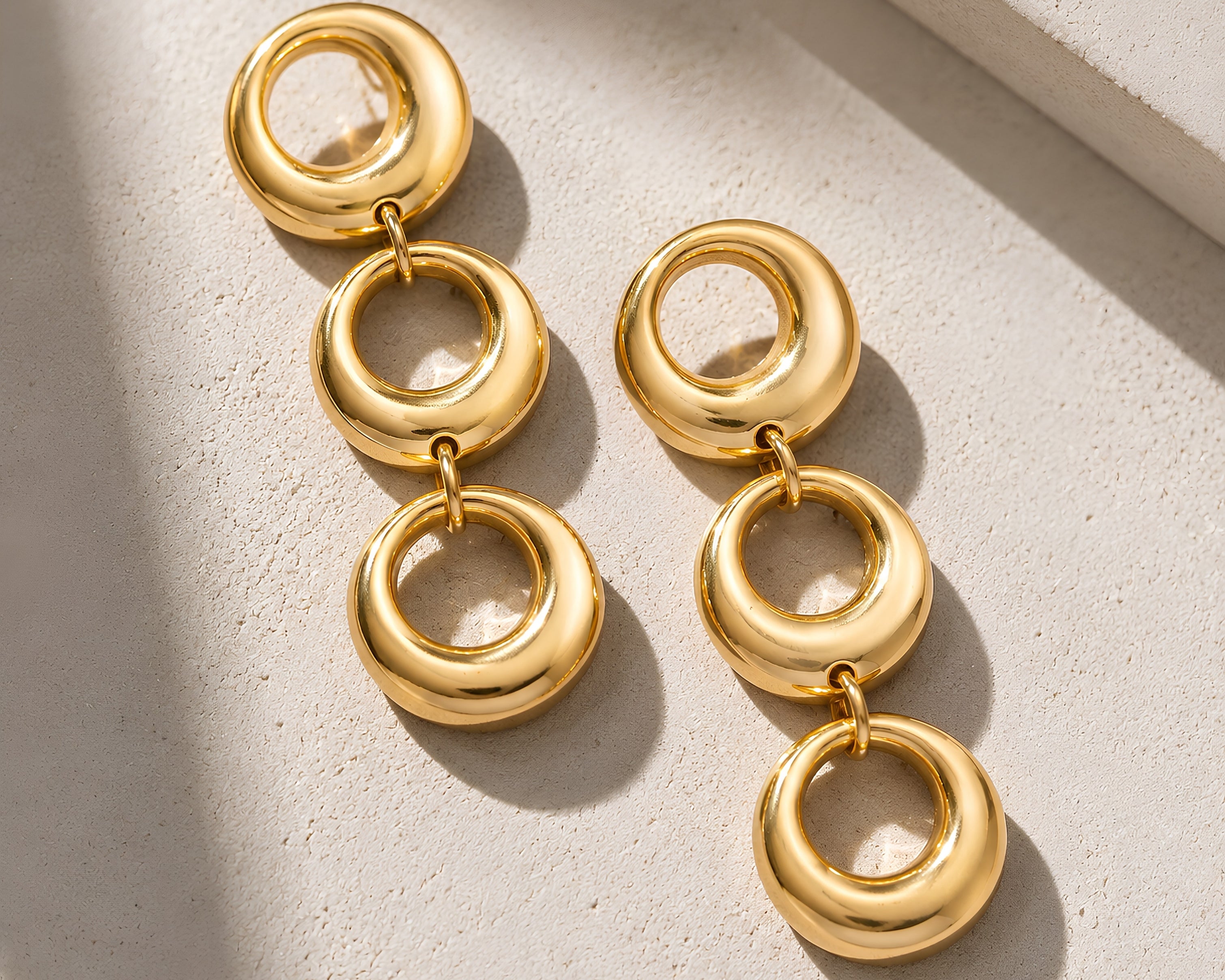 SALVE triple circle drop earrings featuring three interconnected hoops hanging from a delicate chain.