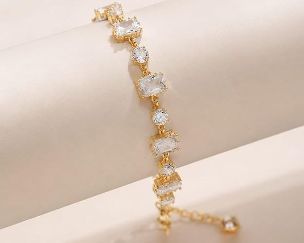 Salve emerald cut and round stone bracelet featuring a stylish design with sparkling green gemstones and silver-tone links.