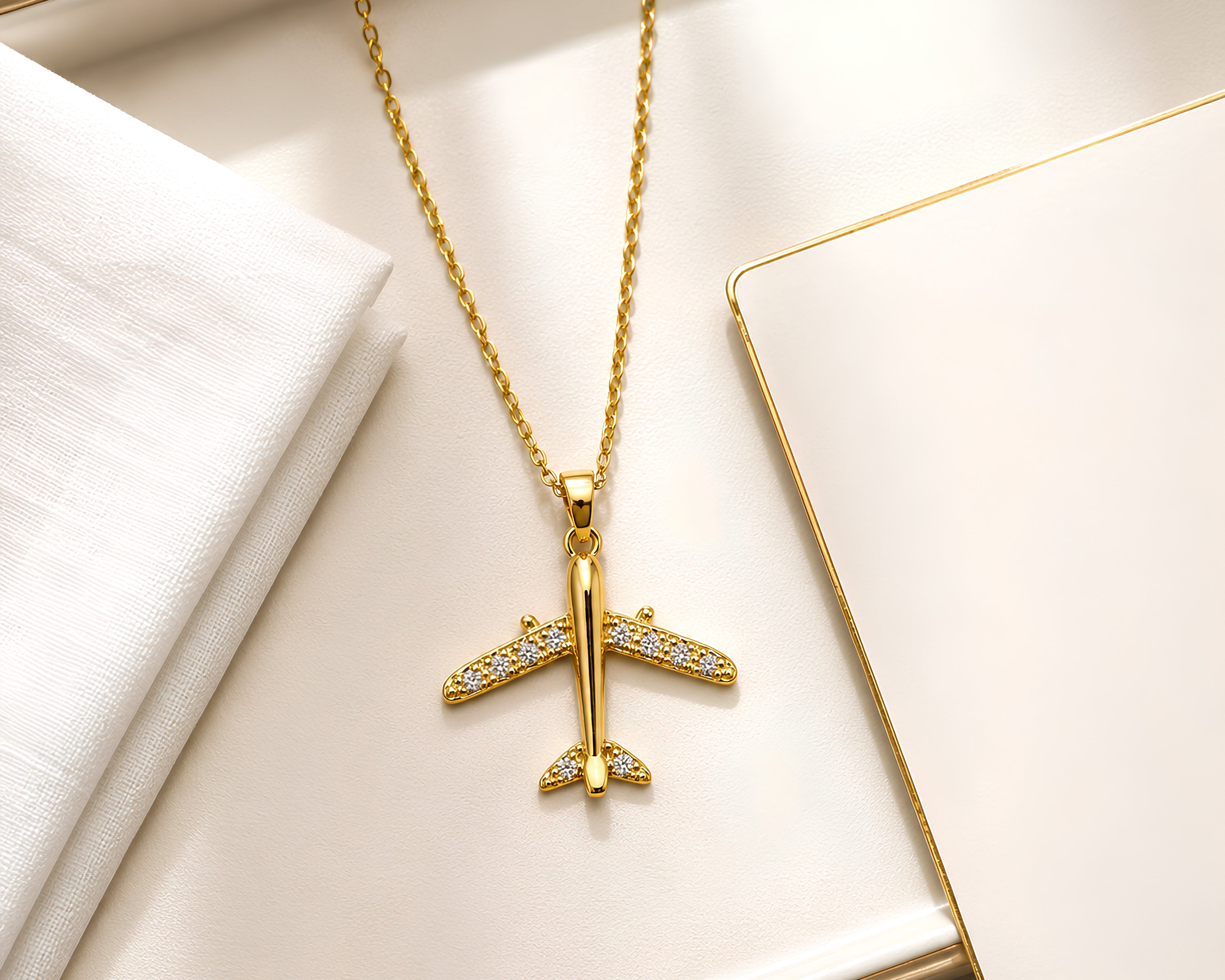 Salve CZ-studded airplane pendant necklace featuring a sleek metal airplane charm with sparkling cubic zirconia accents.