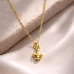 Salve Fleur de Lis pendant necklace featuring a detailed gold-tone charm on a delicate chain.