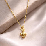 Salve Fleur de Lis pendant necklace featuring a detailed gold-tone charm on a delicate chain.