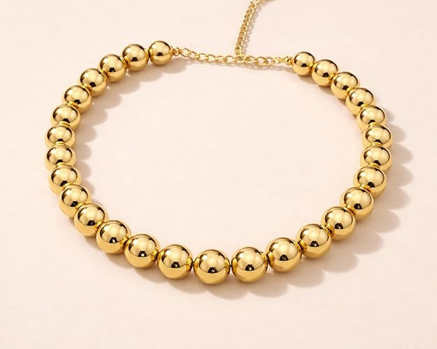 Salve chunky gold beaded aesthetic necklace with large round beads, stylish and trendy jewelry accessory.