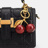 Red glitter cherry keychain from SALVE with sparkling finish and metallic keyring, perfect for accessorizing keys or bags.