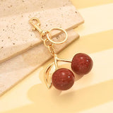 Red glitter cherry keychain by SALVE featuring a sparkling cherry charm with a metal keyring attachment.