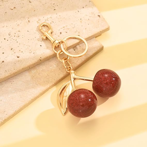 Red glitter cherry keychain by SALVE featuring a sparkling cherry charm with a metal keyring attachment.