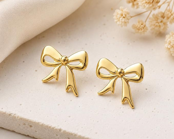 SALVE Coquette Bow Stud Earrings featuring delicate bow design and shiny metal finish, perfect for elegant everyday wear.