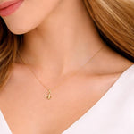 Salve Fleur de Lis pendant necklace featuring a detailed gold-toned charm on a delicate chain, close-up view of the jewelry.