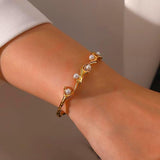 SALVE faux pearl inlaid cuff bracelet featuring a sleek metal band and elegant pearl accents.