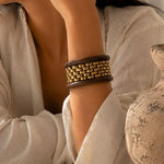 Stack of chunky wooden bangle bracelets from SALVE featuring natural wood textures and a stylish layered look.