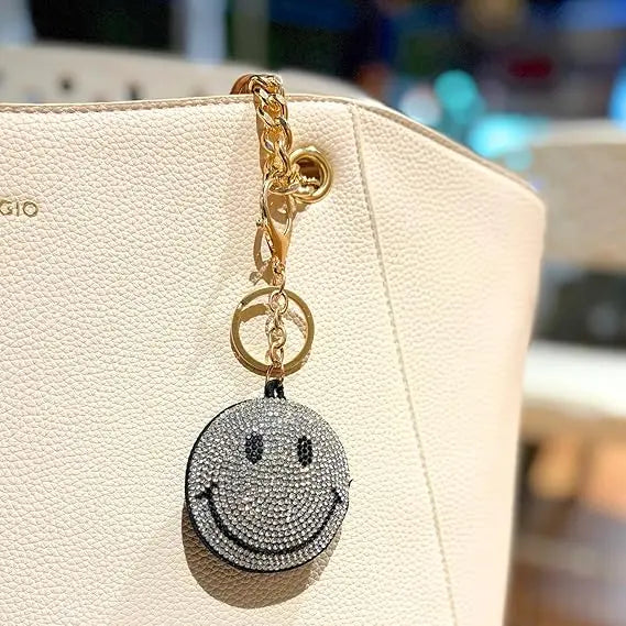 Salve Puffy Smiley Face Keychain with bright yellow plush and embroidered smile, perfect for accessorizing keys or bags.