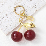 Red glitter cherry keychain from SALVE featuring a sparkling cherry charm with a metal keyring attachment.
