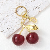 Red glitter cherry keychain from SALVE featuring a sparkling cherry charm with a metal keyring attachment.