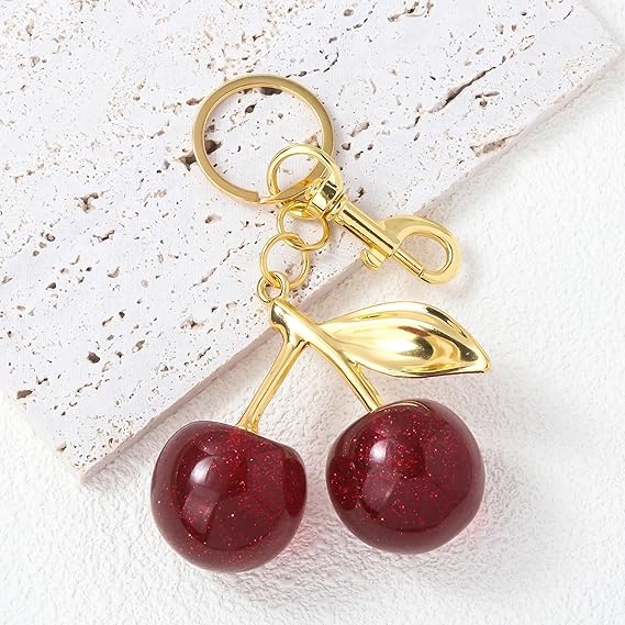 Red glitter cherry keychain from SALVE featuring a sparkling cherry charm with a metal keyring attachment.