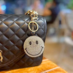 Yellow Puffy Smiley Face Keychain by SALVE with a cheerful smile, soft texture, and attached metal keyring.