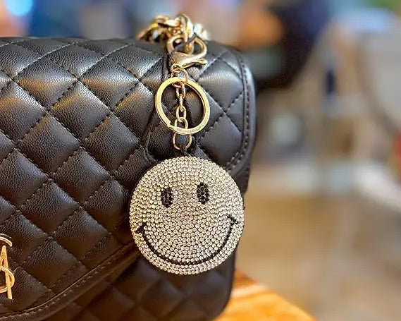 Yellow Puffy Smiley Face Keychain by SALVE with a cheerful smile, soft texture, and attached metal keyring.