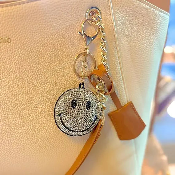 Salve Puffy smiley face keychain with bright yellow plush and embroidered facial features, attached to a metal keyring.