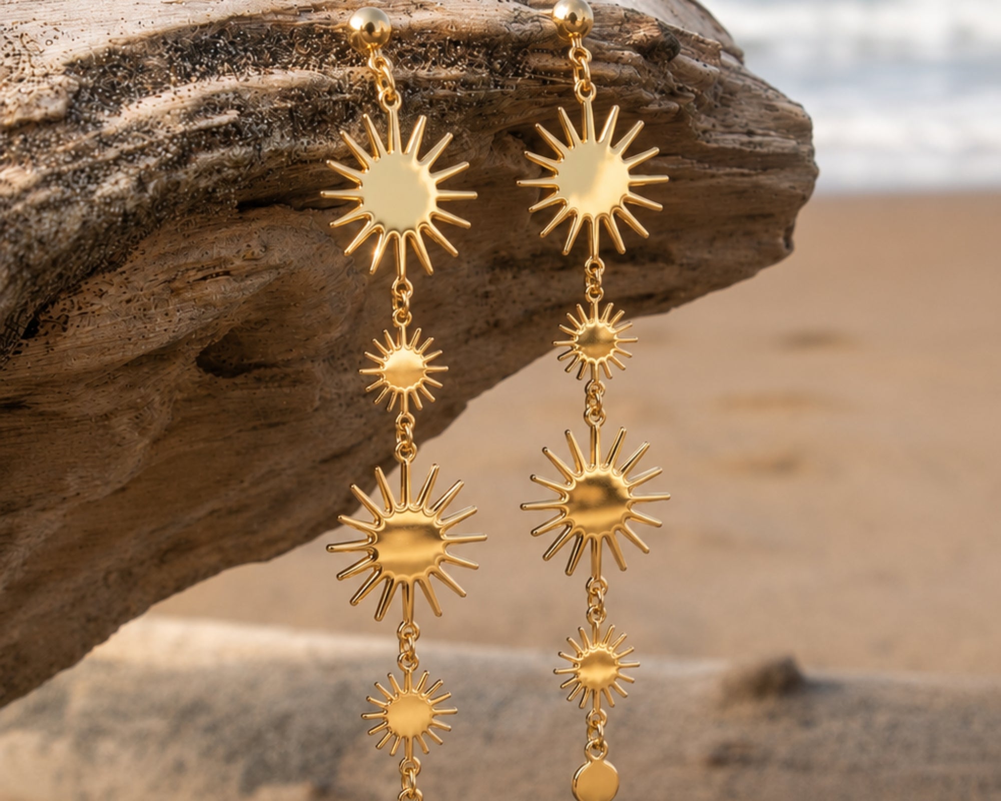 Gold Sun Drop Earrings by SALVE featuring celestial sun design with shimmering gold finish, hanging drop style jewelry.